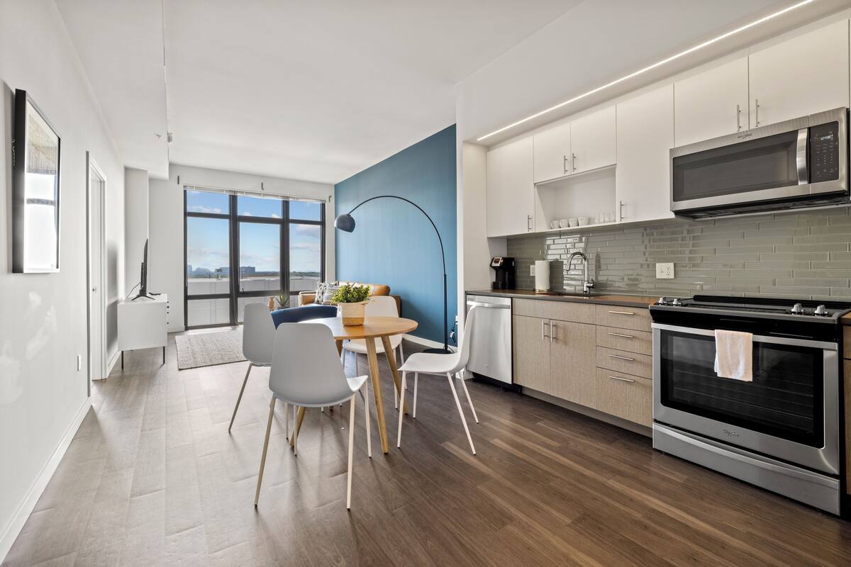 A modern kitchen with white cabinets, a built-in microwave, and a large oven.