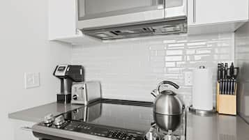 Una cocina moderna equipada con microondas, tostadora, hervidor y cafetera.
