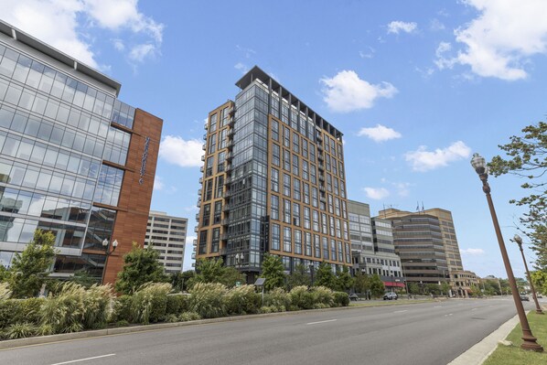 A modern high-rise building with a glass facade and a mix of glass and brown paneling.
