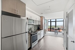 Una cocina moderna con refrigerador, horno y microondas integrados.
