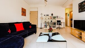 Ein modernes Wohnzimmer mit einer schwarzen Couch, einem weißen Couchtisch und einem Bücherregal.