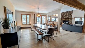 Un'ampia zona giorno con un tavolo da pranzo in legno, panche e un divano.