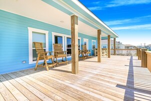 A wooden deck with chairs and a covered area, likely a patio or deck space.