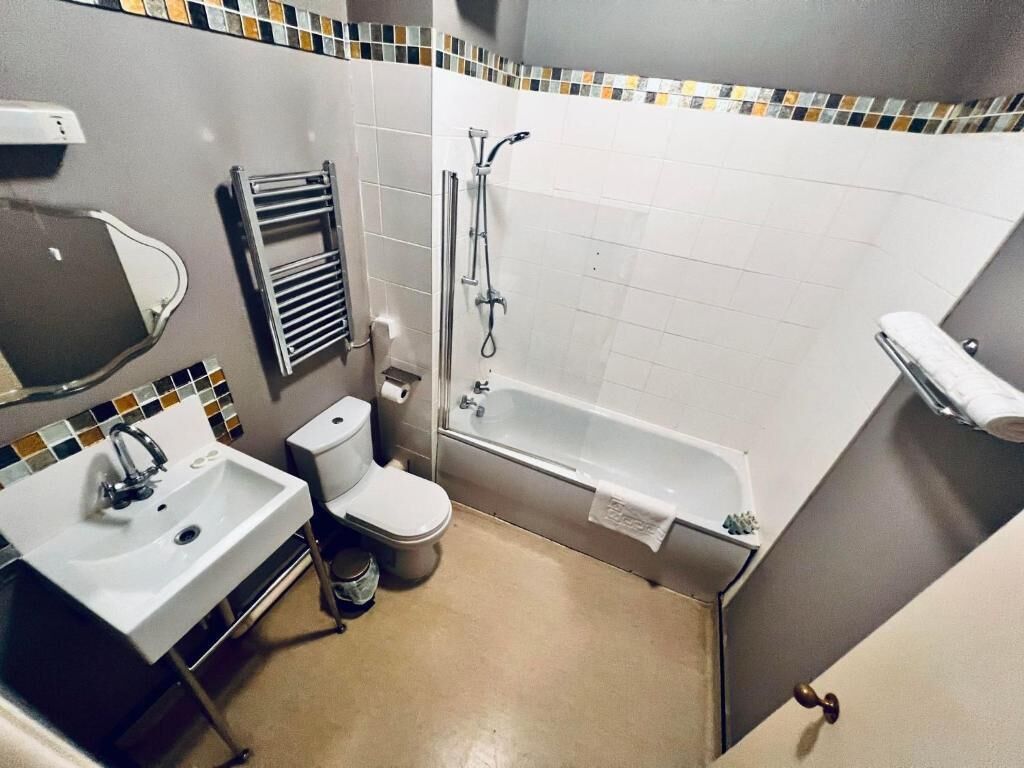A bathroom with a white sink, toilet, and bathtub.