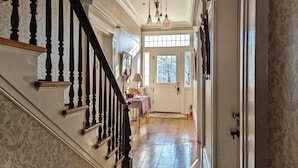 A grand hallway with a wooden staircase, a chandelier, and a door marked "EXIT". - Cromwell Manor Inn (Cornwall)