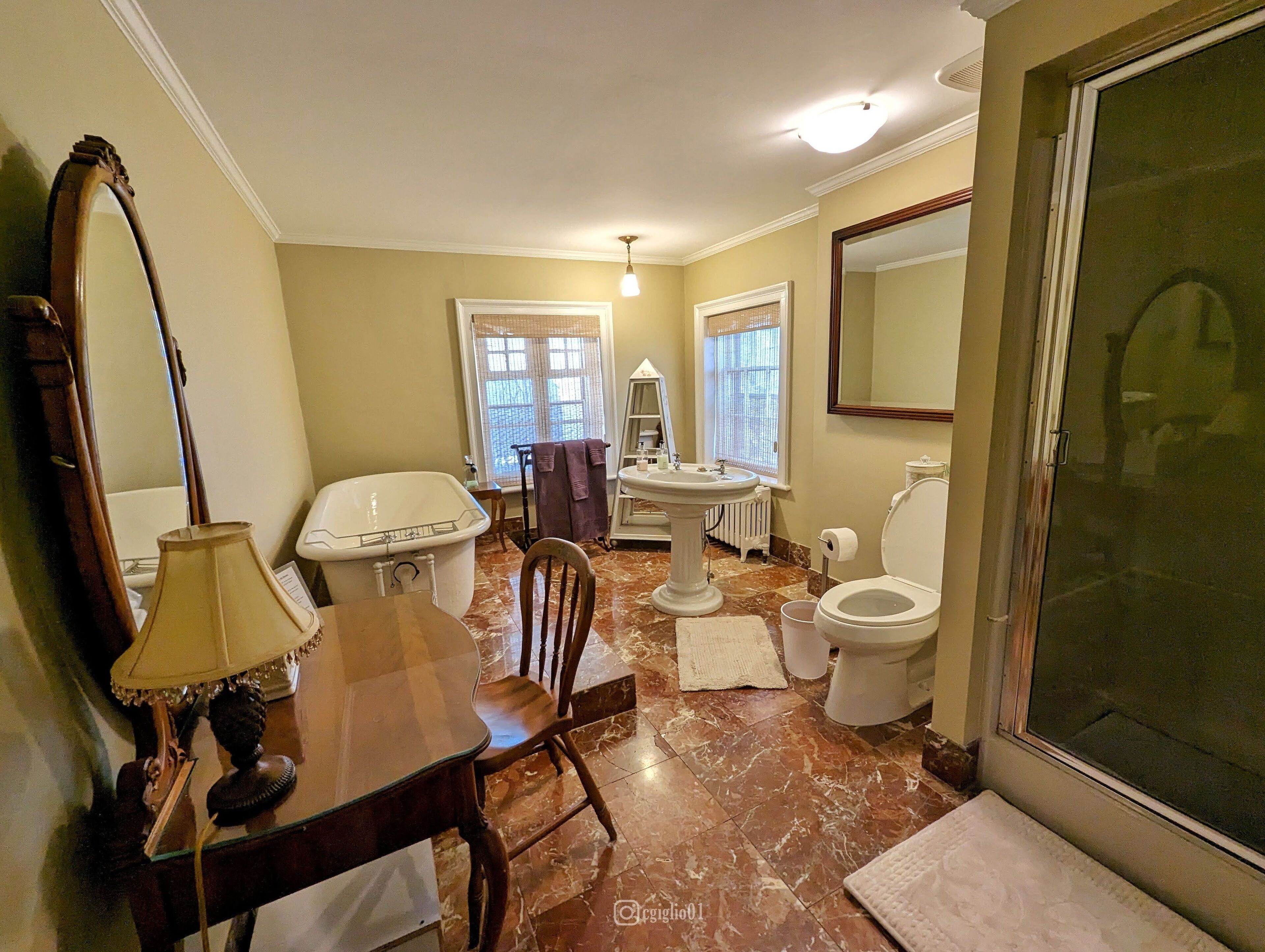 A bathroom with a bathtub, sink, toilet, and a large mirror.