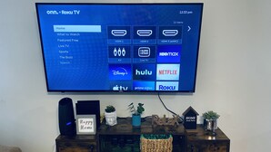 Un téléviseur à écran plat fixé au mur affiche l’interface d’un service de diffusion en continu, proposant différentes options de contenu.