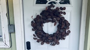 Une porte blanche ornée d’une guirlande, dotée d’un clavier pour ouvrir et d’un paillasson sur lequel est inscrit : « Notre endroit préféré ».