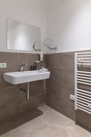 A bathroom with a white sink, mirror, and towel rack.
