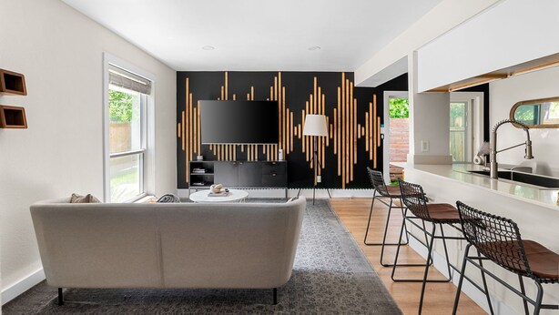 A modern kitchen with a black backsplash, a white countertop, and a built-in stove.