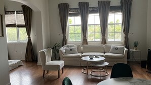 A living room with a ceiling fan, a sofa, a coffee table, and a dining table. - Amazing location.. walk to beach and restaurants.. all furnishings are brand new (Delray Beach)
