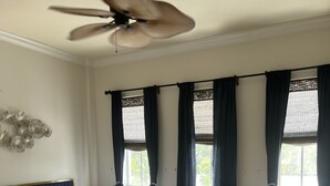A bedroom with a bed, a ceiling fan, and windows with curtains. - Amazing location.. walk to beach and restaurants.. all furnishings are brand new (Delray Beach)