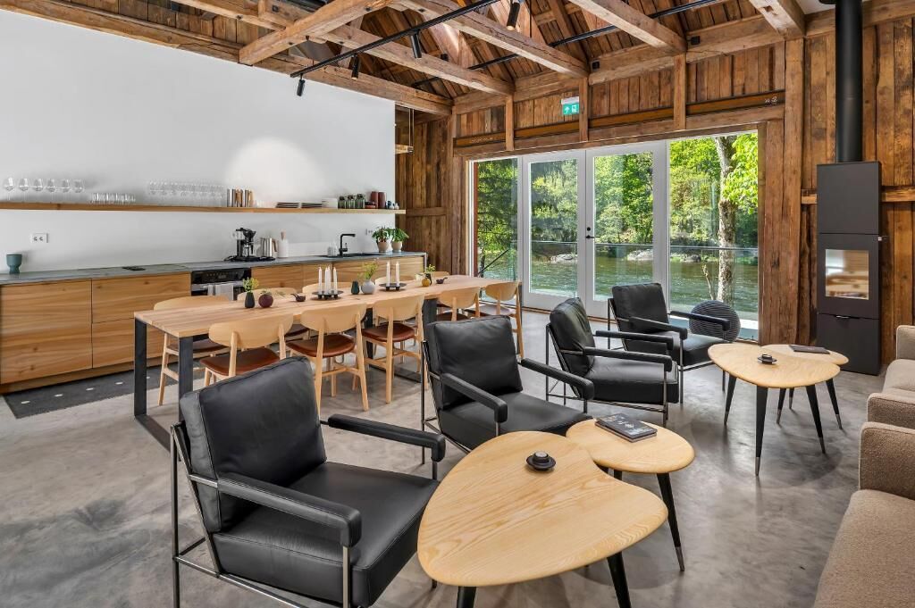A modern kitchen with wooden beams, a bar area, and a seating area with tables and chairs.