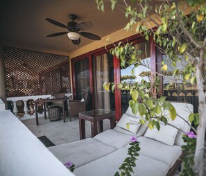 Ein modernes Wohnzimmer mit einer Couch, einem Esstisch und einem Deckenventilator.