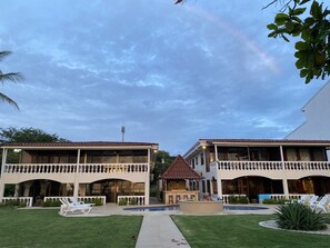 Ein Hotel mit zweigeschossigen Gebäuden, einem Schwimmbad und einem Pavillon.