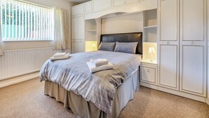 A neatly arranged bedroom with a large bed, bedside lamps, and built-in wardrobes. - 5 bedroom accommodation in Heritage Marina, near Congleton (Heritage Marina, near Congleton)