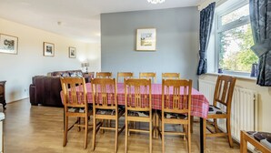 A dining area with a table set for six, wooden chairs, a chandelier, and a window with curtains. - 5 bedroom accommodation in Heritage Marina, near Congleton (Heritage Marina, near Congleton)
