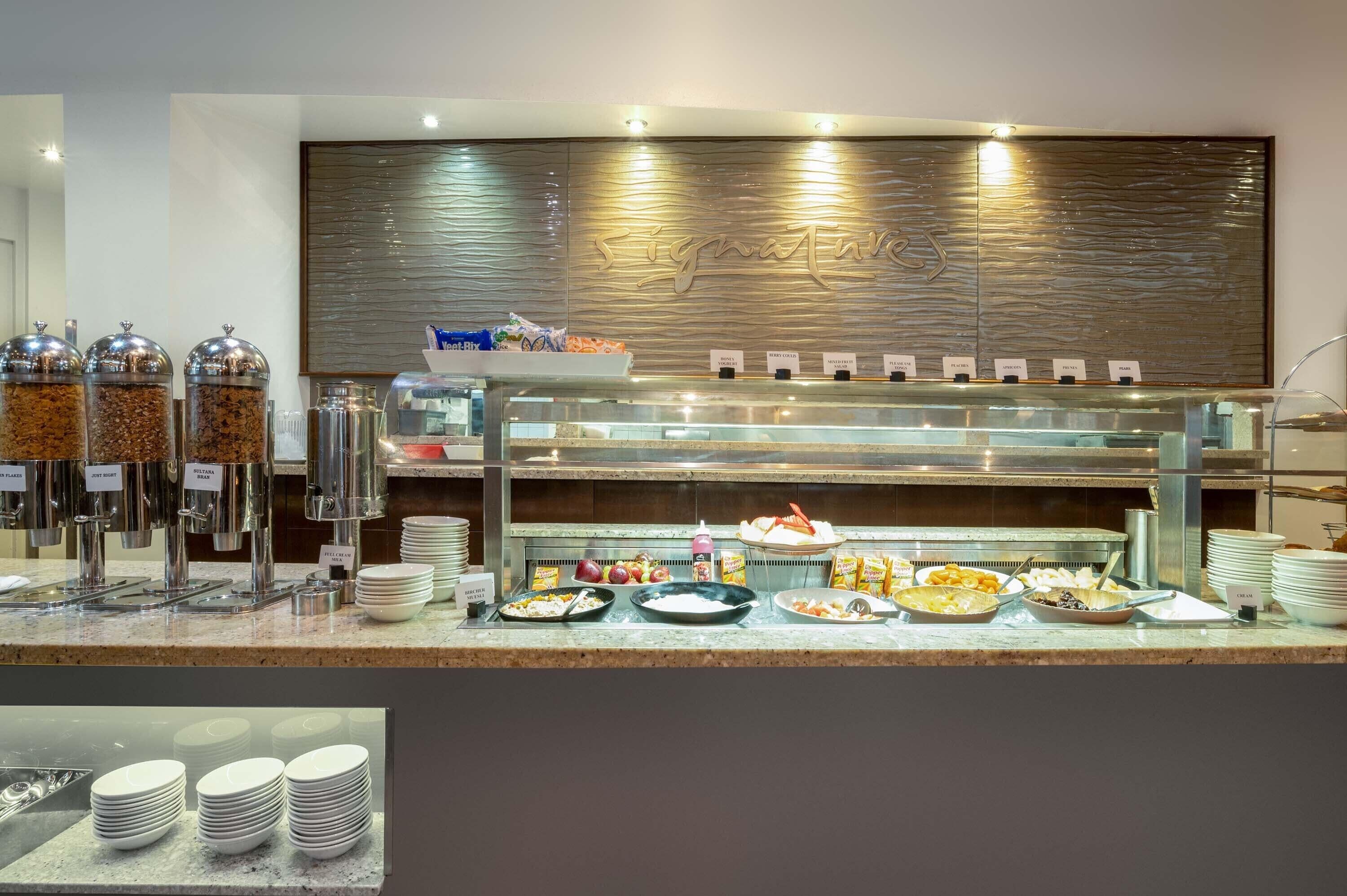 A buffet area with various food stations, including a salad bar and a hot food section.