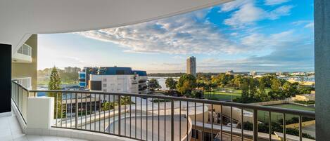 Un balcon offrant une vue sur le paysage urbain, avec des bâtiments et un parc.