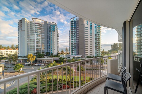 A balcony with a view of high-rise buildings, a road, and greenery. - The Sebel Twin Towns Coolangatta (Tweed Heads)