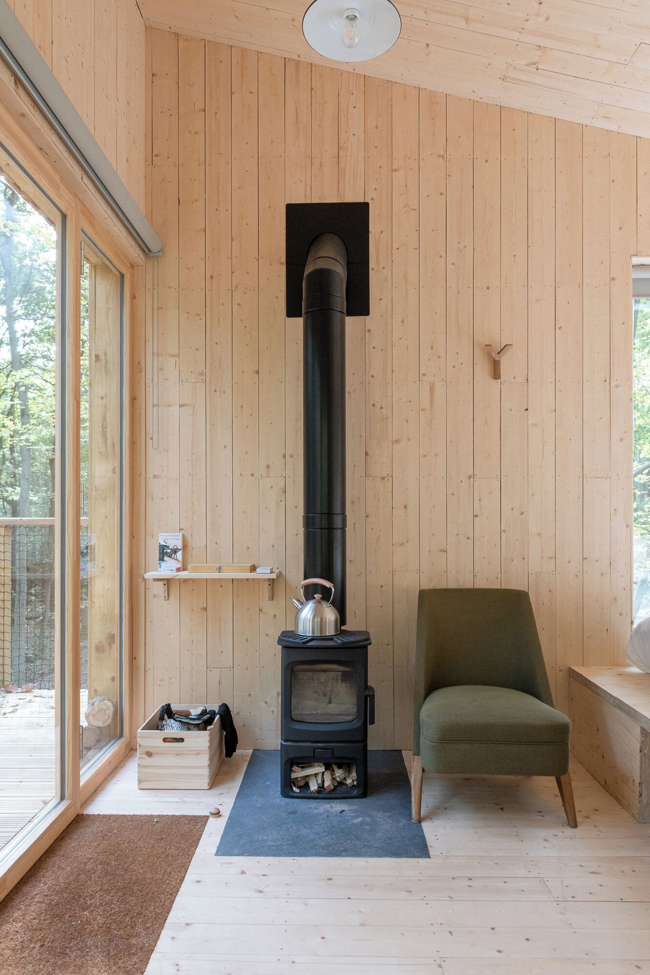 A cozy room with a wood-burning stove, a chair, and a window.