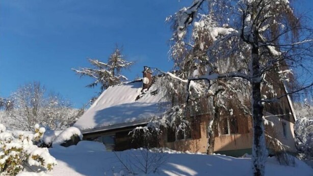 A snow-covered house with a sloped roof and a chimney. - Maison Familiale "les 3 Roches" (Xonrupt-Longemer)