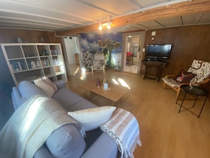 Ein Wohnzimmer mit einer Couch, einem Couchtisch, einem Fernseher und einem Bücherregal.