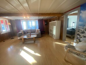 Un salón amplio con sofá, mesa de centro y estantería.