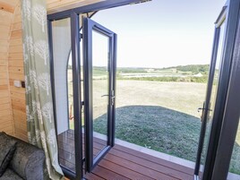 A wooden cabin with a sliding glass door leading to a grassy yard.
