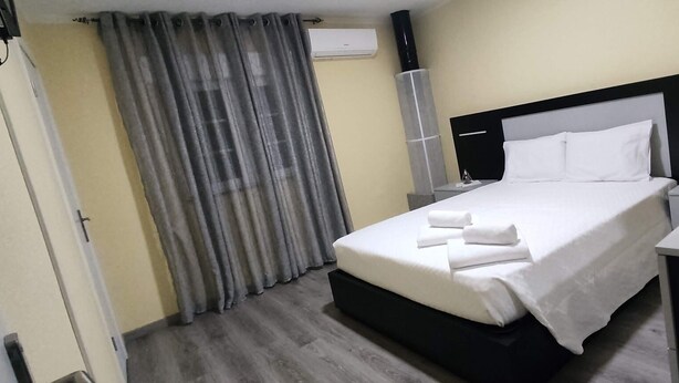A hotel room with a bed, a desk, and a chair.