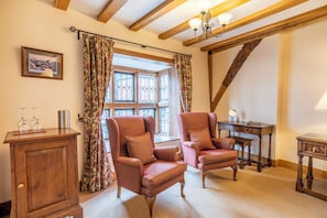 A cozy room with two armchairs, a wooden cabinet, and a desk with a lamp. - Townhouse Ludlow (Ludlow)