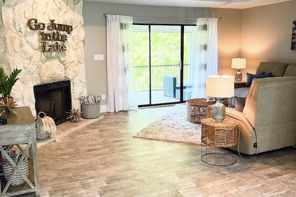 Large living room with lake views, 50" smart TV, and electric sleeper sofa.