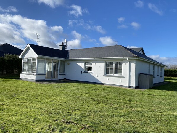Ein Bungalow mit großer Veranda und Garage.