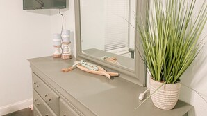 A bathroom vanity with a mirror, a television mounted above, and a potted plant. - Cozy Bungalow, close to the lake.  (Graford)