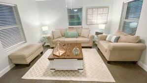 A living room with two beige sofas, a wooden coffee table, and a ceiling fan. - Cozy Bungalow, close to the lake.  (Graford)