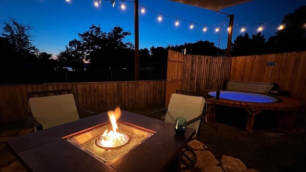 An outdoor patio with a fire pit, seating, and a hot tub. - Cozy Bungalow, close to the lake.  (Graford)