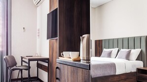 A hotel room with a desk, chair, bed, and a television. - Grand Nur (Tashkent)