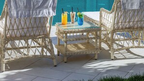 Wicker lounge chairs with white towels, a glass table, and three drinks with straws and garnishes. - Grand Nur (Tashkent)