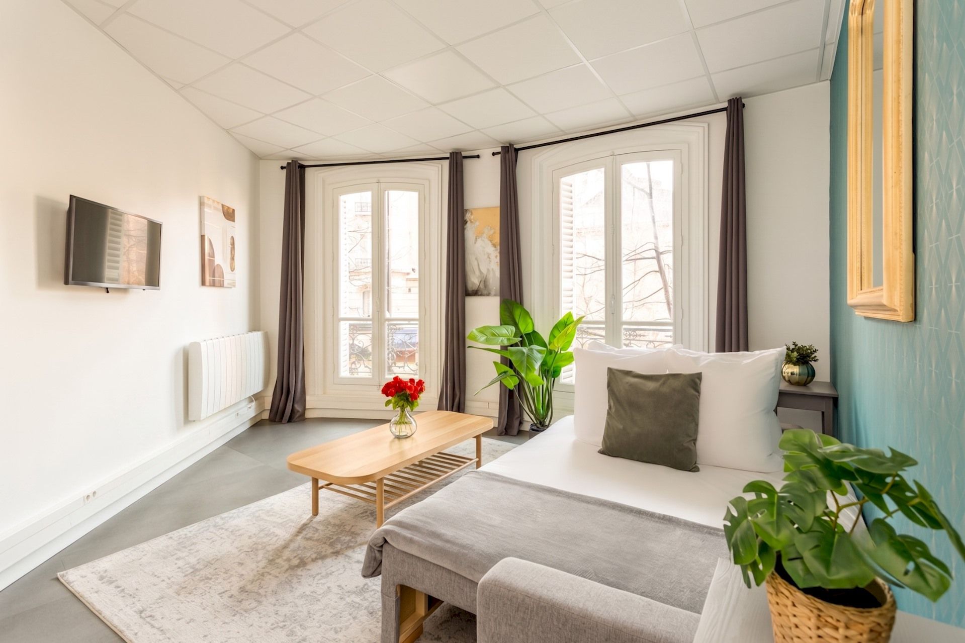 Een moderne kamer met een bed, een tafel en een televisie.