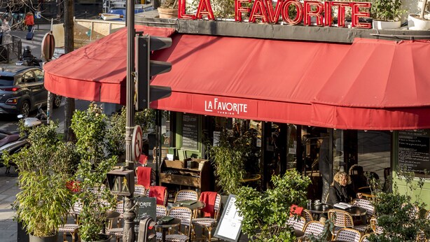 Un café appelé «LA FAVORITE», doté d’une terrasse et agrémenté de plantes en pot.