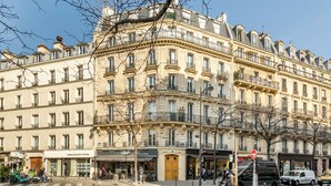 Un immeuble à plusieurs étages, de style architectural classique, doté de balcons et de grandes fenêtres.