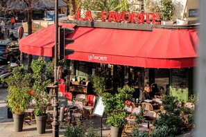 A cafe named 'LA FAVORITE' with outdoor seating and a red awning. - Family Suite - Marais - Turbigo I (Paris)