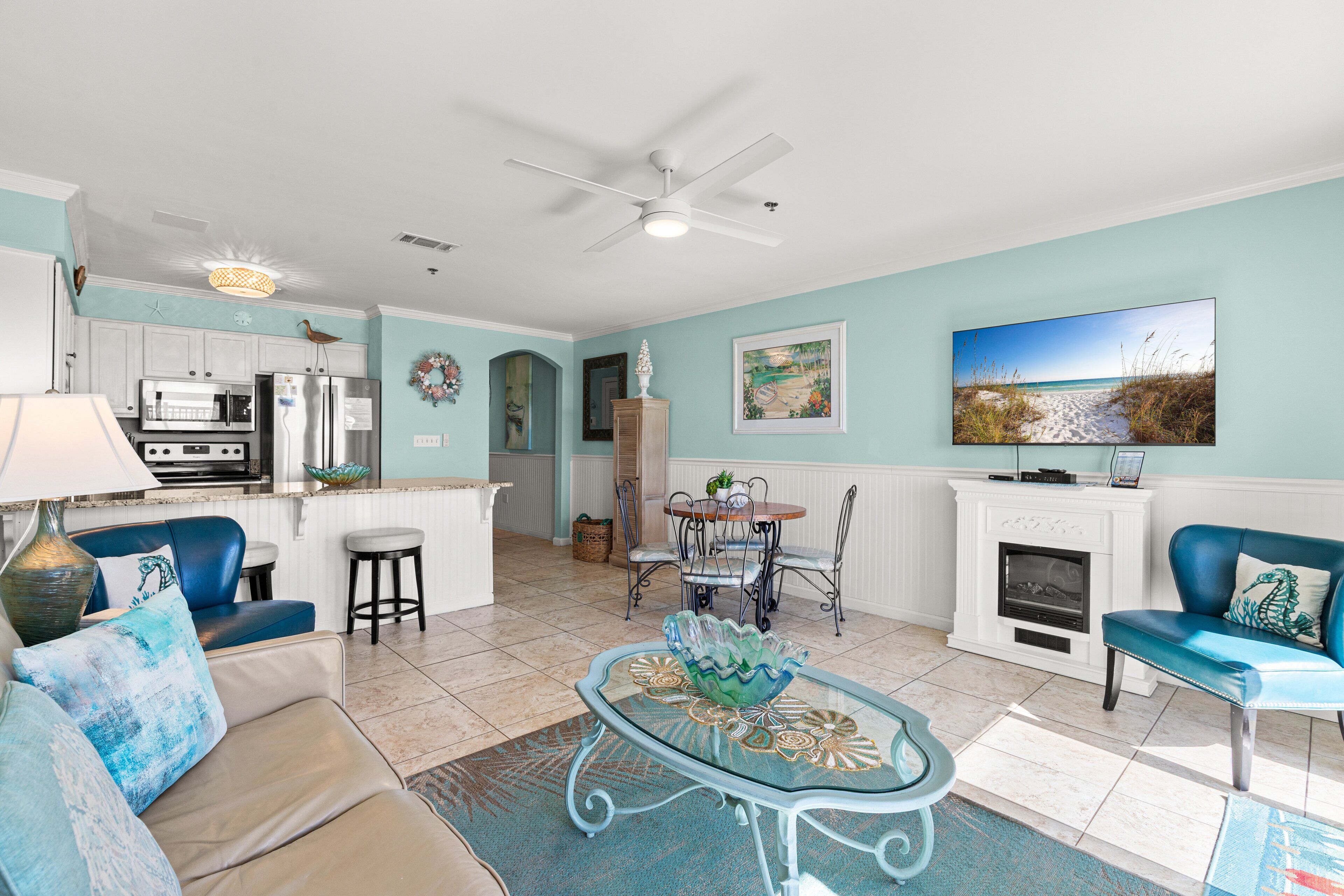 A spacious living room with a dining area, a kitchen, and a fireplace.