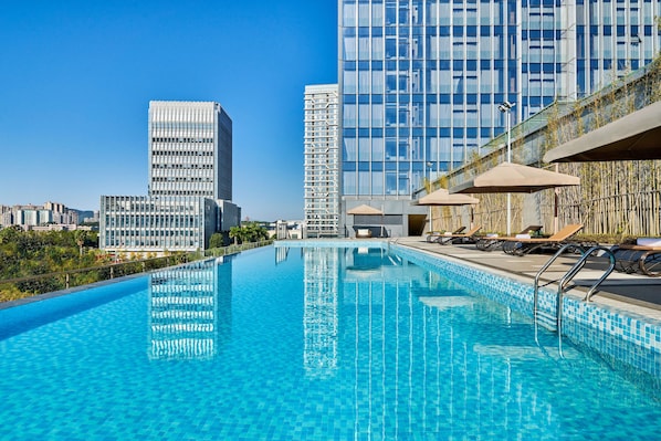 Piscine extérieure, parasols de plage, chaises longues