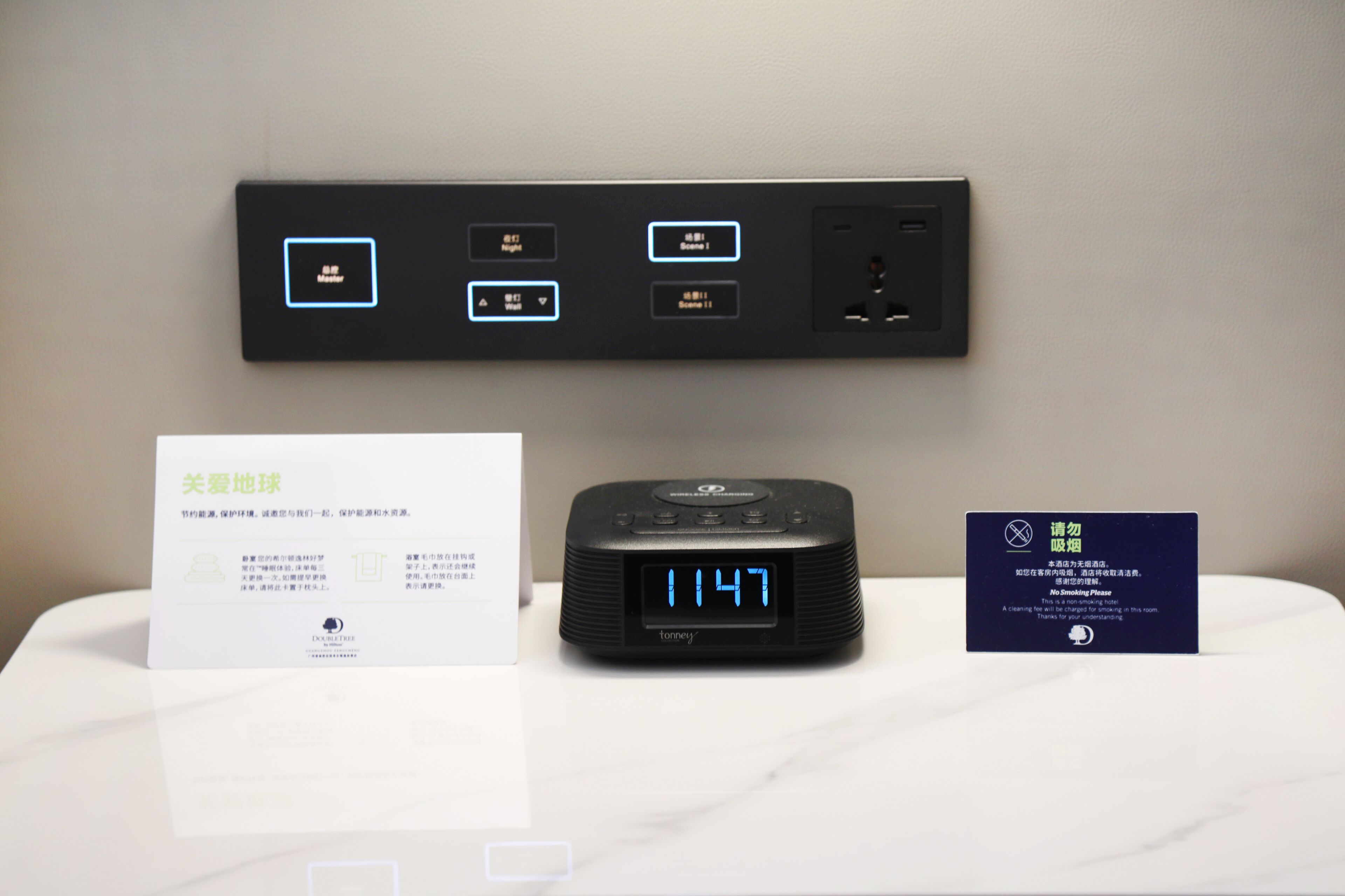 Um relógio digital mostra 11:47, um aviso de proibido fumar e um painel de controle com vários botões e indicadores.