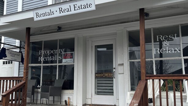 A two-story building with a sign for 'Rentals Real Estate' and a 'Rest & Relax' sign on the front.