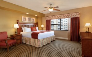Relax in this inviting room with a large bed, bedside tables, and a ceiling fan.