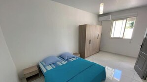 Une chambre à coucher avec un lit, une armoire et une fenêtre.