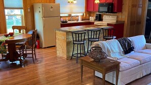 Un espacio habitable compacto con cocina, comedor y sofá.