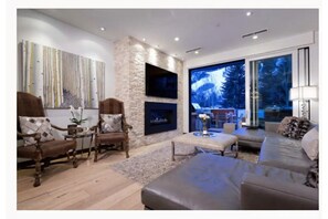 Relax in this stylish living room with a fireplace, flat-screen TV, and a window offering a view of the surrounding landscape.